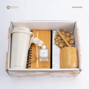 Hampers Calm Moment dari Dekayu berisi lampu meja hias gold, storage jati, shower gel, reed diffuser, bath bomb, woodslice akasia, dan Box Foil Forest sebagai hadiah relaksasi yang elegan.